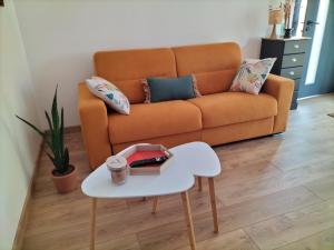 a living room with a couch and a table at Les Iris in Les Herbiers