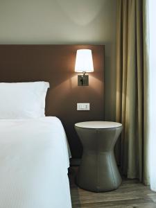 a bedroom with a bed and a lamp on a wall at MOVE Hotels Venezia Nord in Mogliano Veneto