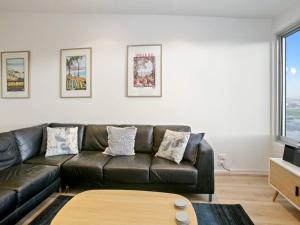 a living room with a brown leather couch and a table at Bay Vue - Absolute Oceanviews in Apollo Bay