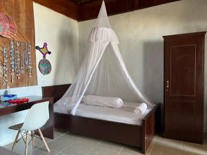 um quarto com uma cama e uma rede mosquiteira em Mangkombong Homestay em Tapokreng