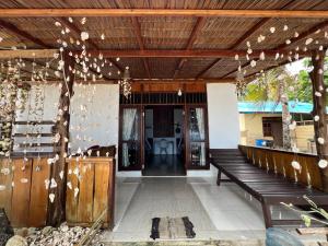 a porch with a wooden ceiling and a bench at Mangkombong Homestay in Tapokreng