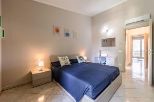 um quarto com uma cama com um edredão azul em Moderna Suite con ampio terrazzo - Free WiFi & Parking em SantʼAgata sul Santerno