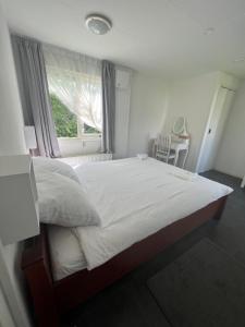 a bedroom with a large bed with a window at Ruime chalet midden in de natuur in Lith in Lith