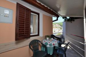 a table and chairs on a balcony with a window at Apartments Lory in Rabac +22 photos