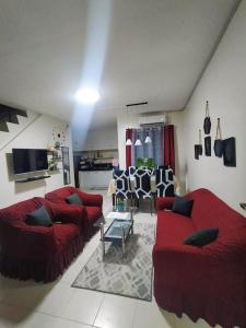 a living room with two red couches and a table at Miestee's Sweet Home in Lapu Lapu City
