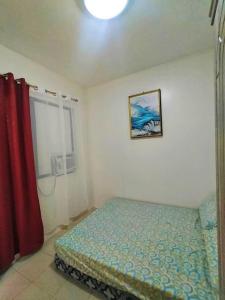 1 dormitorio con cama y cortina roja en Miestee's Sweet Home, en Lapu Lapu City