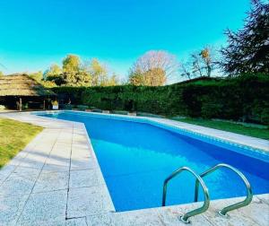 a swimming pool with blue water in a yard at Tiny House in Mendoza