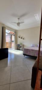 - une chambre avec un lit et une chambre avec une table dans l'établissement Casa de 2 andares a 150m da praia! - Prainha de Mambucaba, Paraty - RJ, à Parati
