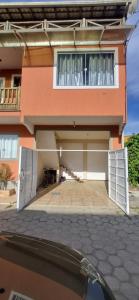 une maison avec deux portes de garage devant elle dans l'établissement Casa de 2 andares a 150m da praia! - Prainha de Mambucaba, Paraty - RJ, à Parati