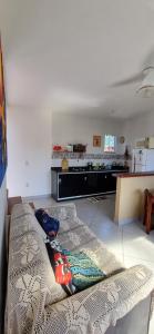 uma sala de estar com um sofá e uma cozinha em Casa de 2 andares a 150m da praia! - Prainha de Mambucaba, Paraty - RJ em Paraty