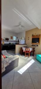 uma sala de estar com um sofá e uma mesa em Casa de 2 andares a 150m da praia! - Prainha de Mambucaba, Paraty - RJ em Paraty
