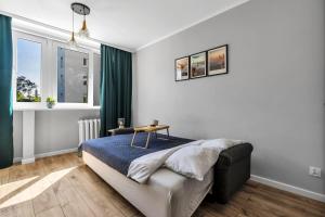 a bedroom with a bed and a table in it at Warsaw City Center Studio - Park, Subway Nearby - by Rentujemy in Warsaw
