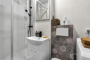 a white bathroom with a sink and a shower at Warsaw City Center Studio - Park, Subway Nearby - by Rentujemy in Warsaw