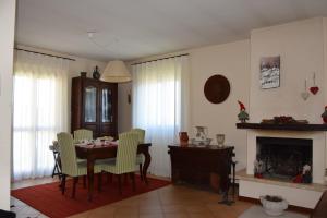 une salle à manger avec une table, des chaises et une cheminée dans l'établissement Casa Palmira, à Pescocostanzo