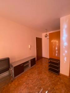 una sala de estar vacía con TV y sofá en Studios & Apartments Perla, en Sunny Beach