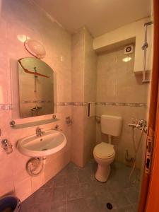a bathroom with a sink and a toilet and a mirror at Studios & Apartments Perla in Sunny Beach