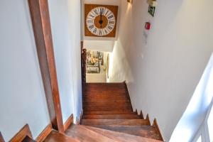 a stairway with a clock on the wall at Bozzali Deluxe Hotel in Chania