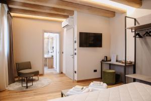 Habitación con cama, escritorio y TV. en Ca'Lisel, en Valdobbiadene
