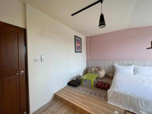 富世村的住宿－遊手浩賢民宿，卧室配有白色的床和绿色凳子