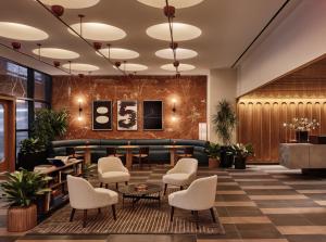 a lobby with a waiting area with chairs and tables at Romer Hell's Kitchen in New York