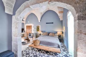 a bedroom with a king sized bed and a stone wall at Bambarone La Masseria in Fasano