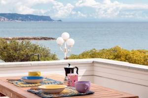 einen Tisch mit Schalen und Tassen auf einem Balkon mit Meerblick in der Unterkunft Les Voiles - Trilocale sul mare in Ceriale