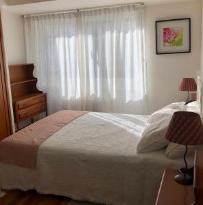 um quarto com uma cama grande e uma janela em Apartamento en el centro na Corunha