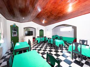 a restaurant with green tables and chairs on a checkered floor at Equatorial Park Clube in Abaetetuba