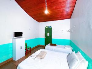 two beds in a room with a wooden ceiling at Equatorial Park Clube in Abaetetuba