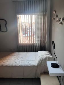 a bedroom with a bed and a table and a window at Apartamento El Colibri in Cordoba