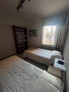a bedroom with two beds and a desk and a window at Apartamento El Colibri in Cordoba