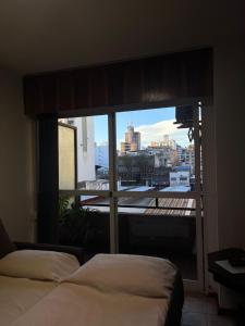 a bedroom with a window with a view of a city at Apartamento El Colibri in Cordoba +12 photos