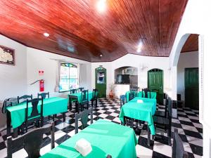 a dining room with green tables and chairs at Equatorial Park Clube in Abaetetuba