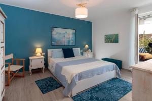 ein blaues Schlafzimmer mit einem Bett und einer blauen Wand in der Unterkunft Les Voiles - Trilocale sul mare in Ceriale