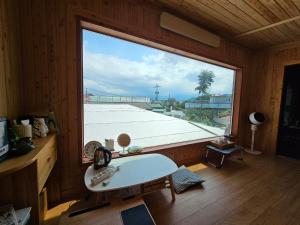 a room with a large window with a table and a view at Today Jeju Yongdam in Jeju