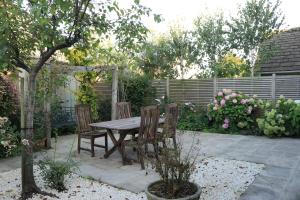 a table and chairs in a garden with a fence at Beautiful Cottage in the Heart of Stow on the Wold in Stow on the Wold