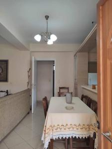 a dining room with a white table and a kitchen at Calm & equipped vacation house 