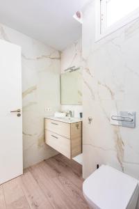 La salle de bains blanche est pourvue d'un lavabo et de toilettes. dans l'établissement VILLA MARACUYÁ, à Tías