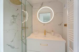un baño con lavabo y espejo en Neptune, en Trouville-sur-Mer