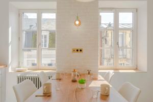 Un comedor con mesa y sillas y ventanas. en Neptune, en Trouville-sur-Mer