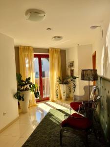 a living room with a red chair and a window at Aparthotel Gaja in Bled +71 photos