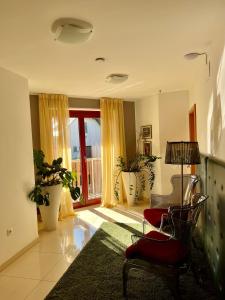 sala de estar con silla roja y ventana en Aparthotel Gaja, en Bled