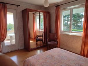 una camera con letto, sedia e finestre di Villa Amarante ad Annonay
