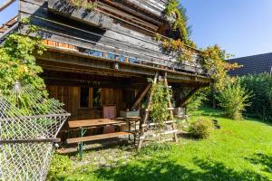 an old wooden house with a bench in the yard at Charmantes Ferienhaus mit Garten in Siegsdorf