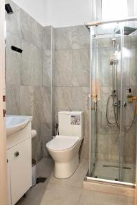 ein Bad mit einem WC und einer Glasdusche in der Unterkunft Nikos apartment in Malia