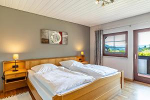 Schlafzimmer mit einem Bett mit weißer Bettwäsche und einem Fenster in der Unterkunft Ferienwohnung Decker in Oberkirch