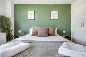 um quarto com uma cama grande e paredes verdes em Spacious and Pristine Home - Free Parking em Northampton