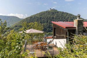 a house with a deck with a table and an umbrella at Ferienwohnung Am Samuelstein in Bad Urach