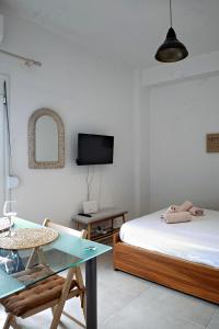 Zimmer mit 2 Betten, einem Tisch und einem TV in der Unterkunft Nikos apartment in Malia
