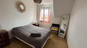 sypialnia z łóżkiem i lustrem w obiekcie La Palmerais Dinard - 5 min de la plage w mieście Dinard